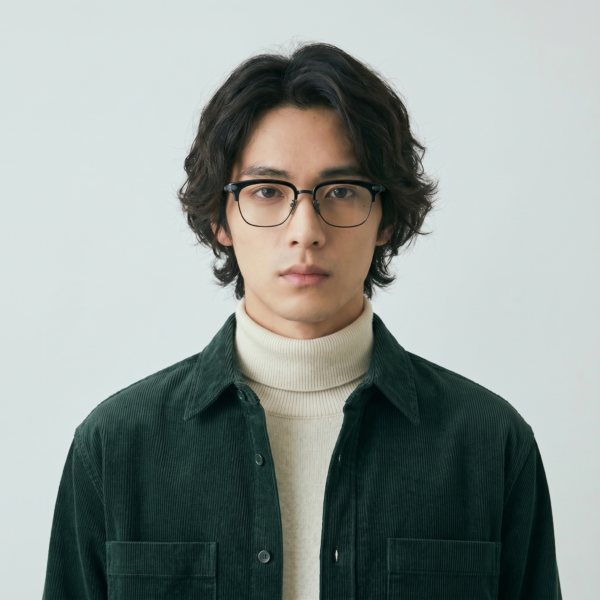 A strong browline and semi-rimless titanium construction give worn by a model
